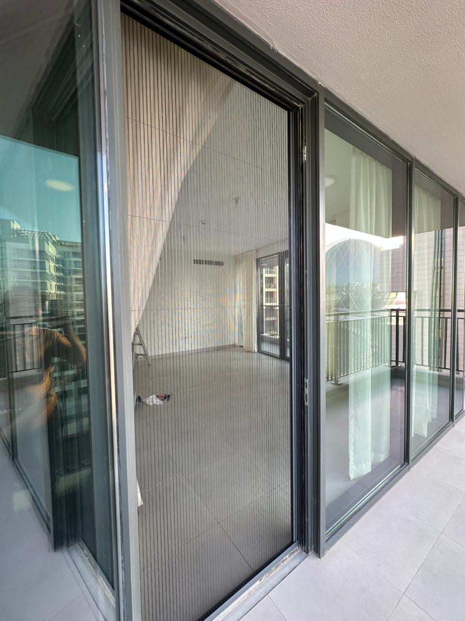 Blind screen curtain fitted to a tall sliding balcony door in a Dubai apartment