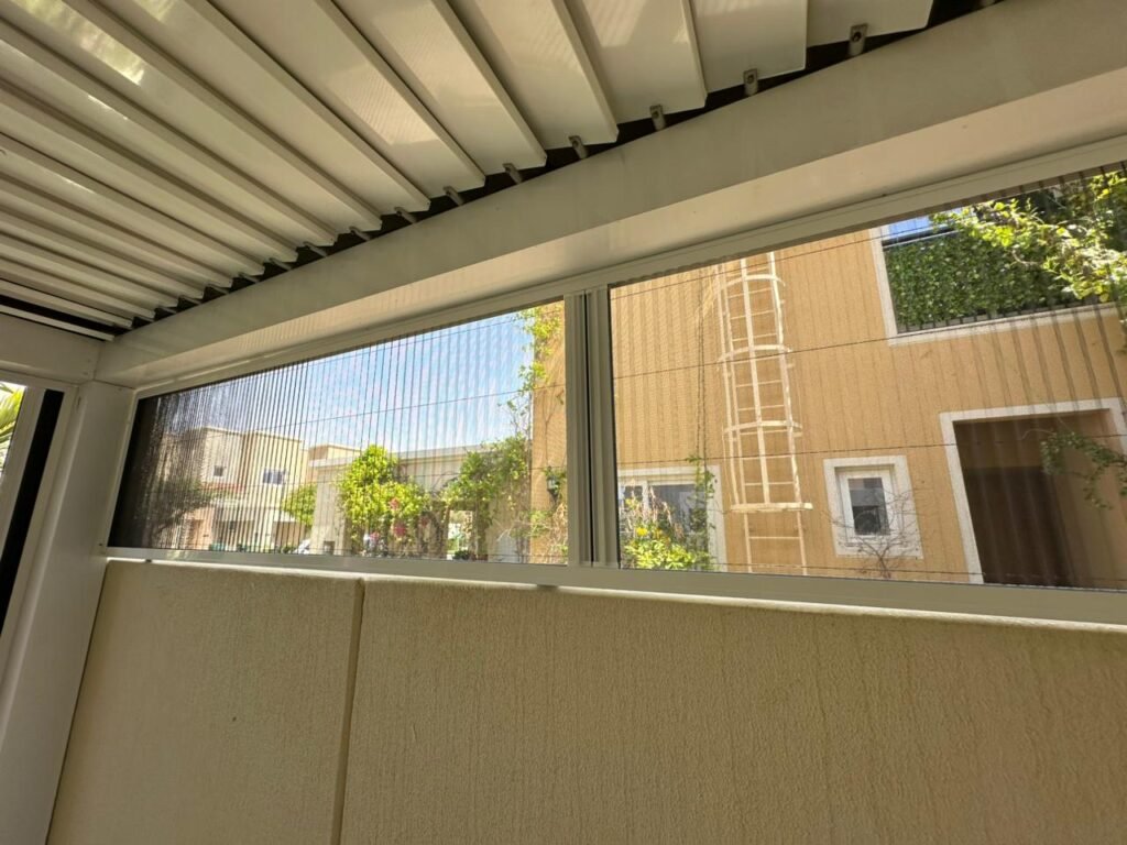 Mosquito net screen installed under pergola slats on a Dubai balcony enclosure