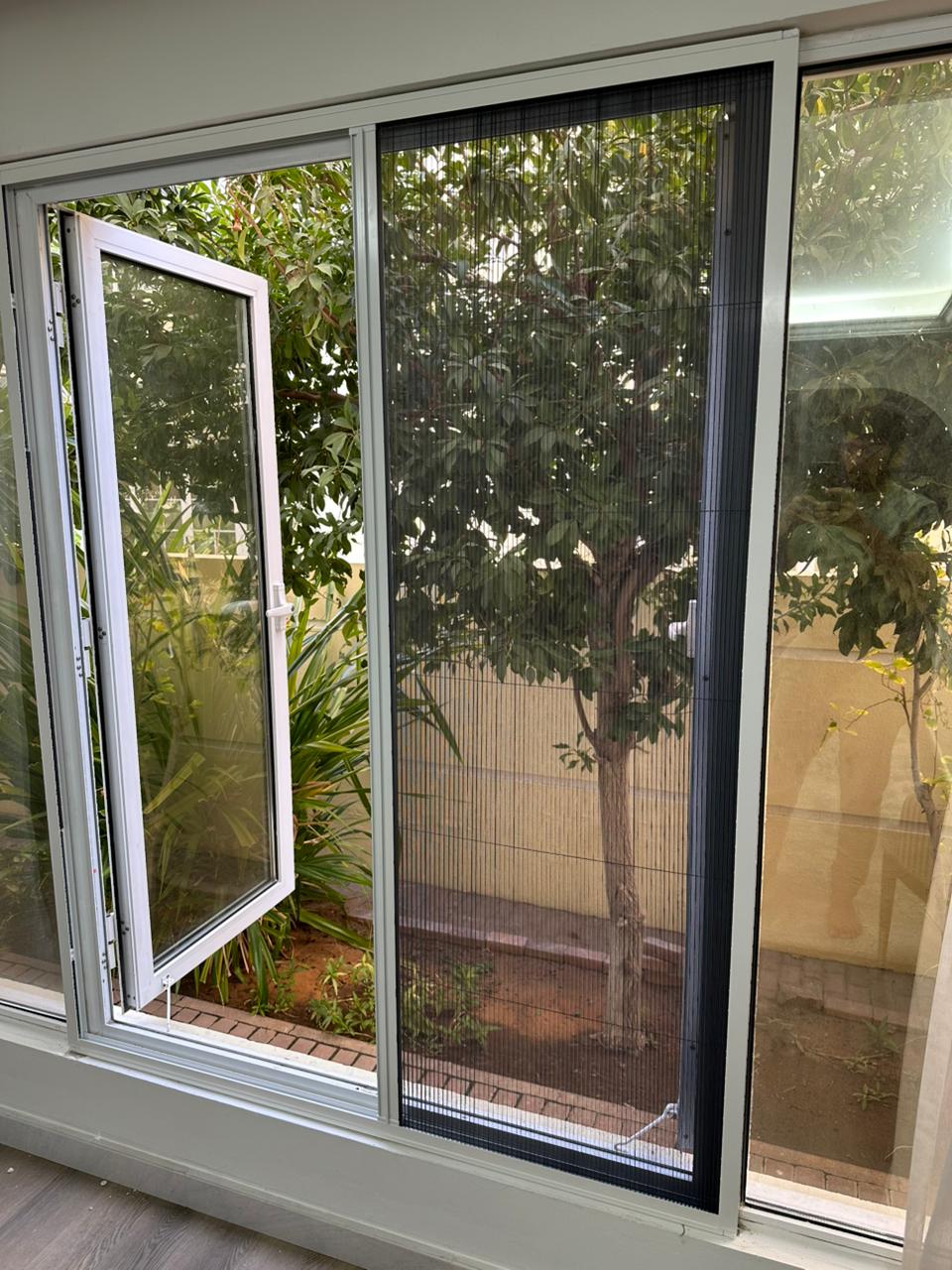 Installer fitting a made-to-measure mosquito screen to a Dubai window